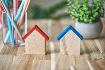 木目のテーブルに置かれた2つの家
