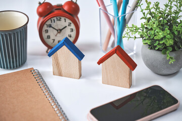 2つの木製の家とスマホと雑貨