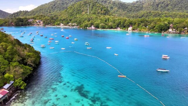 Motorboats Docked Along Shoreline of Emerald Waters