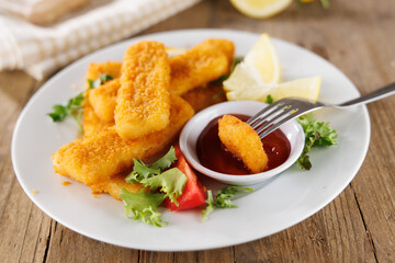 golden fried fish fingers sticks with salad and ketchup