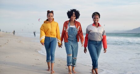 Fototapeta premium Happy women, walking and holding hands with friends on beach for holiday, weekend or strolling in nature. Young, female person or group with smile for outdoor vacation or social by ocean coast