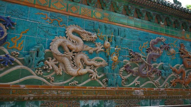 Nine Dragons Wall in Beihai Park with colorful reliefs of dragons, Beijing, China. Panning right shot