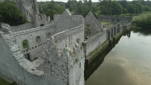 Ruins Of Adare Castle And Green Golf Course Club Near River Maigue In County Limerick, Ireland. Aerial Ascending Shot