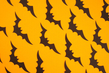 Vibrant bat silhouettes against a bright yellow background in a playful Halloween pattern