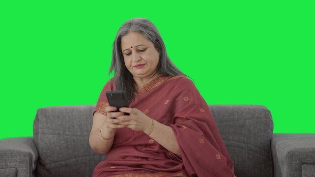 Angry Indian old woman chatting on phone Green screen