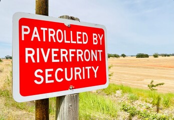 Patrolled By Riverfront Security red roadway sign.