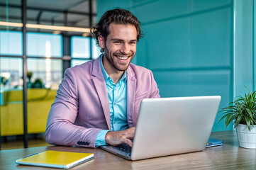 Fototapeta premium Business person manager man working in vibrant colorful illuminated light office, sitting at desk workplace, looking at laptop monitor, typing on keyboard, talking on smartphone. Digital art style.