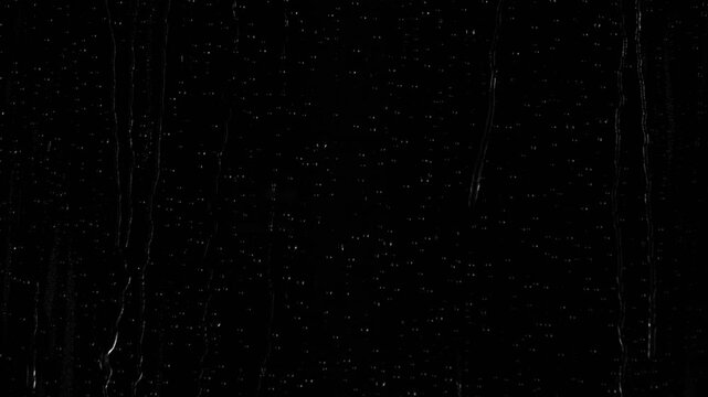 Closeup water rainfall, rain drops falling on window glass over black background