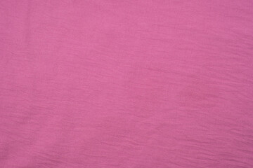 Fototapeta premium A vibrant pink fabric spread out on a flat surface, showcasing its texture and color