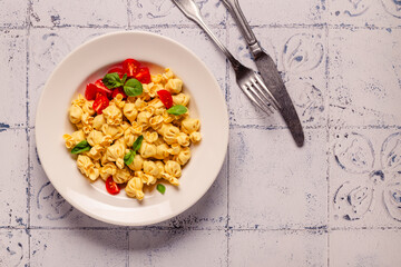 Sacсhettini pasta in a plate with tomato sauce.