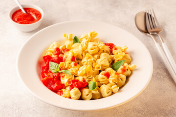 Sacсhettini pasta in a plate with tomato sauce.
