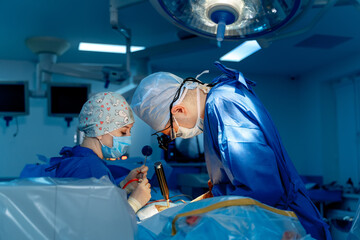 Surgical team operating in sterile conditions. Surgical professionals collaborate closely during an...