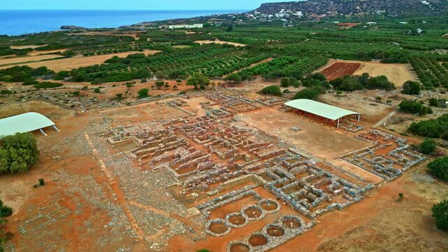 Ancient ruins of a Greek palace near the sea with distant hills and green fields
