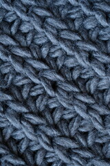 macro texture of woolen dark gray crocheted sweater as background, close-up of gray crocheted front surface, woolen texture of woolen wool, knitted front surface