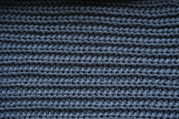macro texture of woolen dark gray crocheted sweater as background, close-up of gray crocheted front surface, woolen texture of woolen wool, knitted front surface