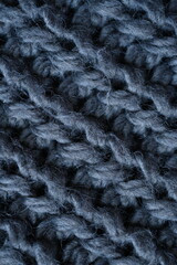 macro texture of woolen dark gray crocheted sweater as background, close-up of gray crocheted front surface, woolen texture of woolen wool, knitted front surface