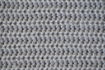 macro texture of woolen pastel crocheted sweater as background, close-up of brown crocheted front surface, woolen texture of woolen wool, trend pastel crocheted front surface