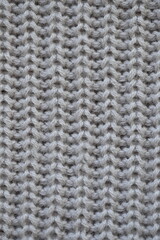 macro texture of woolen pastel crocheted sweater as background, close-up of brown crocheted front surface, woolen texture of woolen wool, trend pastel crocheted front surface