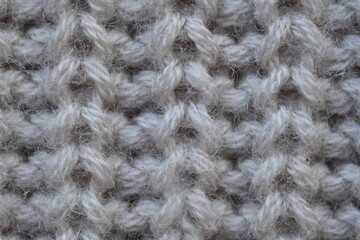 macro texture of woolen pastel crocheted sweater as background, close-up of brown crocheted front surface, woolen texture of woolen wool, trend pastel crocheted front surface