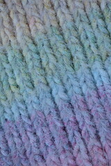 Macro texture of acrylic multicolored crocheted sweater as background, close up of rainbow front surface, multicolored crocheted wool texture, crocheted front surface