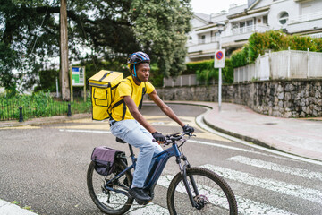 Obraz premium African food delivery cyclist riding through a residential neighborhood on his bike
