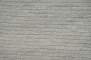 macro texture of woolen white crocheted sweater as background, close-up of blue crocheted front surface, woolen texture of woolen wool, crocheted front surface