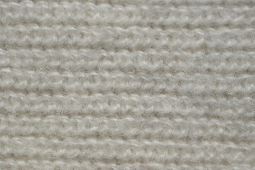 macro texture of woolen white crocheted sweater as background, close-up of blue crocheted front surface, woolen texture of woolen wool, crocheted front surface