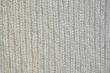 macro texture of woolen white crocheted sweater as background, close-up of blue crocheted front surface, woolen texture of woolen wool, crocheted front surface