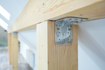 Wood in construction. Close up photo with metallic plates used to joint pieces of wood during the construction of a house.