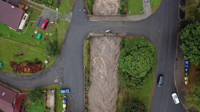 Drone top shot of stron current river with bridge and strangers