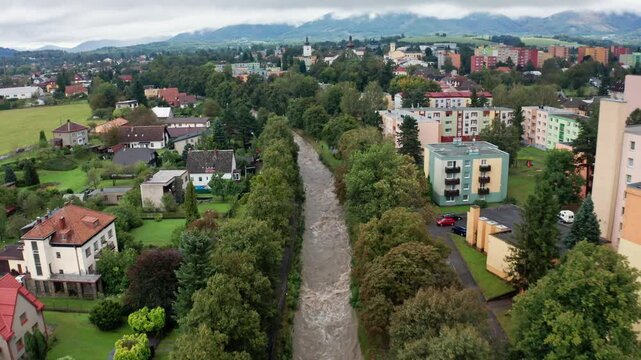 Drone shot of strong current river in the city under mountains