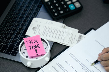 'Tax time' memo on 1040 individual tax form. Need help and taxes text on stickers with tax forms. Assistance with filing tax form and calculation.