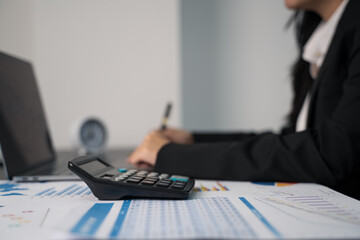 Doing taxes. Planning budget and calculating expenses while checking her bills with calculator. Managing taxes and financial bills.