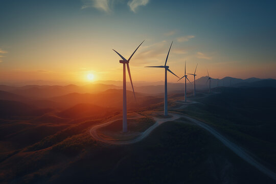 Aerial view of wind turbines silhouetted against a rising sun
