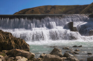 Obraz premium artificial waterfall on a dam on the Lepsy River in Kazakhstan in summer.