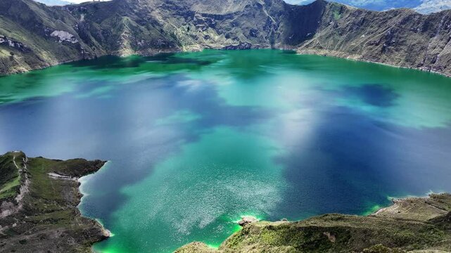 Incredible Quilotoa lake from volcano crater filled with water, Ecuador. Aerial forward