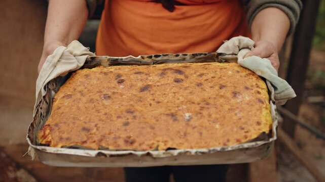 Woman showing the camera the Paraguayan soup, ready to eat. Paraguayan soup is the only solid soup in the world