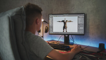 Young designer creates 3D model and animation of game character using computer. Interface of professional 3D modeling software. Teen boy working on freelance project on PC at home. Game development.