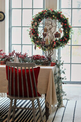 a large Christmas wreath in red hangs on the wall in the living room