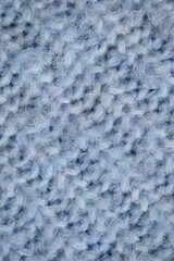 macro texture of woolen blue crocheted sweater as background, close-up of blue crocheted front surface, woolen texture of woolen wool, knitted front surface