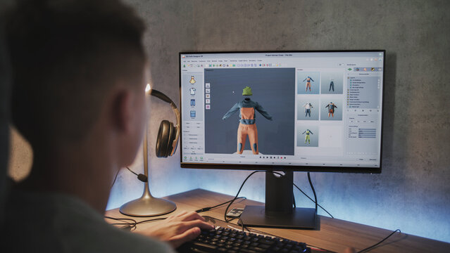 Young designer creates and draws clothes using PC. Interface of professional 3D modeling or design software. Teenage boy working on freelance project on computer at home. Game development concept.