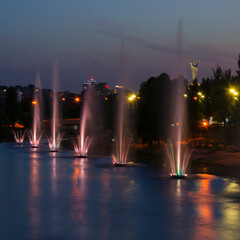 Kyiv night cityscape, color fountain on the embankment of Dnipro river, Rusanivka historical district, capital of Ukraine