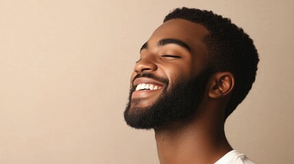 Obraz premium Smiling young man with a beard enjoying a moment of happiness against a neutral background