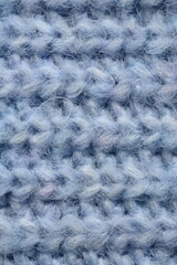 macro texture of woolen blue crocheted sweater as background, close-up of blue crocheted front surface, woolen texture of woolen wool, knitted front surface