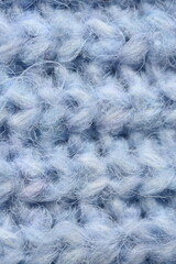 macro texture of woolen blue crocheted sweater as background, close-up of blue crocheted front surface, woolen texture of woolen wool, knitted front surface