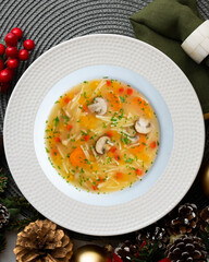 Short noodle soup with vegetables and mushrooms. Top view table with Christmas decoration.