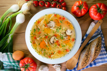 Short noodle soup with vegetables and mushrooms. Top view table with  decoration.