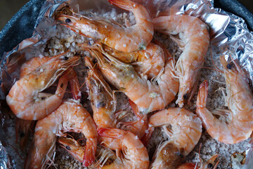 Grilled shrimps baked red on a pan and foil