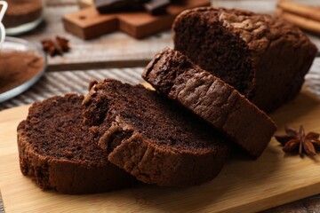 Delicious cut chocolate sponge cake on wooden table, closeup