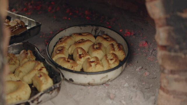Paraguayan chipa baking at high temperatures in the tatakua, a traditional Paraguayan clay oven. Chipa is made during Holy Week